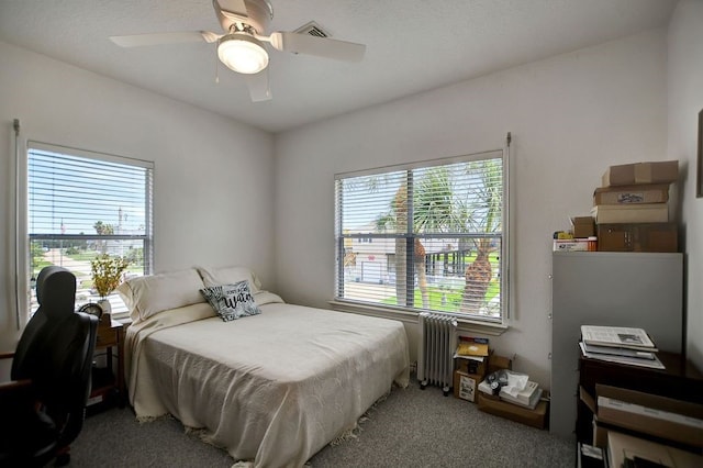 carpeted bedroom with radiator heating unit and ceiling fan