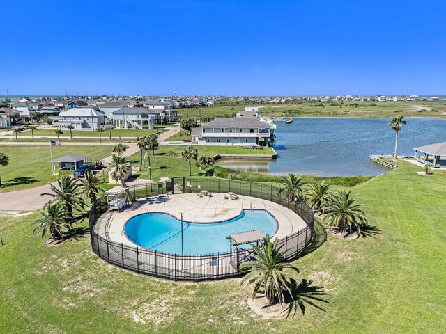 view of swimming pool with a yard, a patio area, and a water view