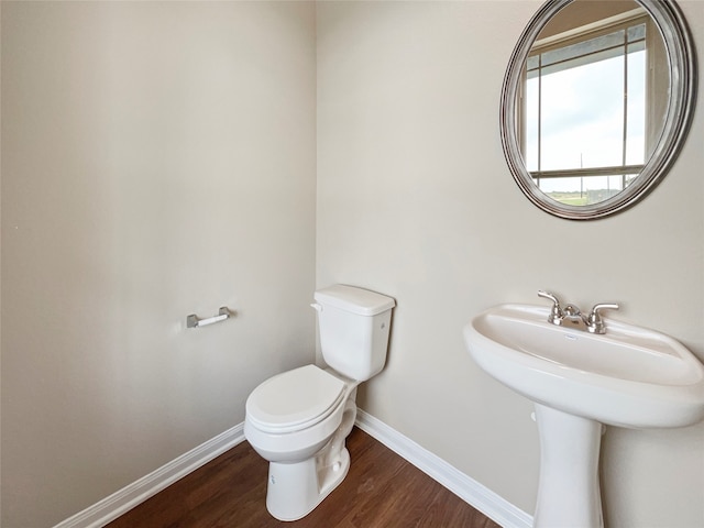 bathroom featuring wood-type flooring and toilet