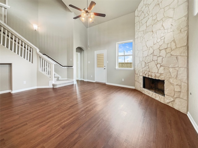 unfurnished living room featuring high vaulted ceiling, ceiling fan, dark hardwood / wood-style flooring, and a fireplace