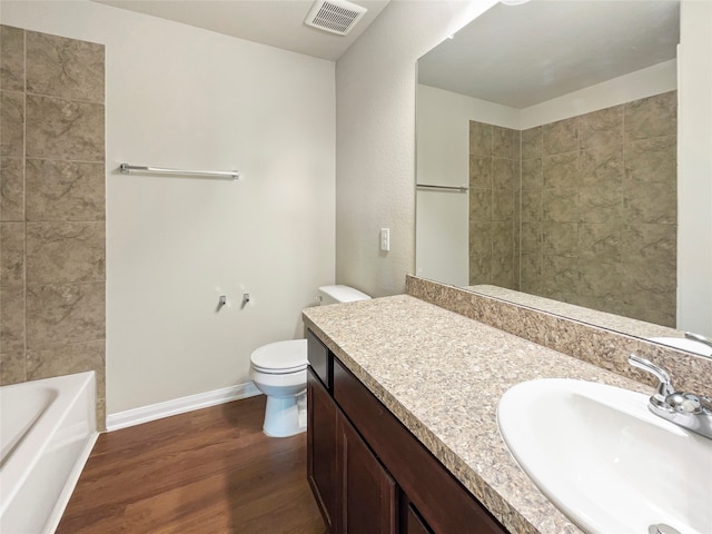 full bathroom with tiled shower / bath combo, hardwood / wood-style flooring, toilet, and vanity