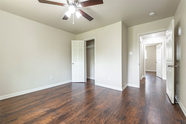 unfurnished bedroom featuring dark wood-type flooring, a closet, and ceiling fan