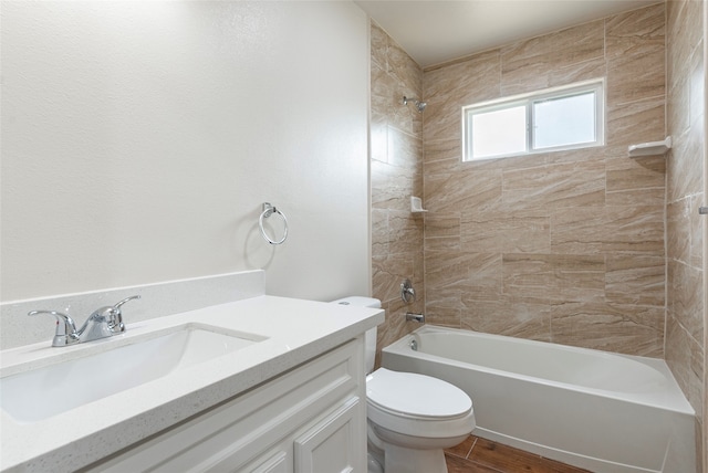 full bathroom featuring tiled shower / bath, vanity, toilet, and tile flooring