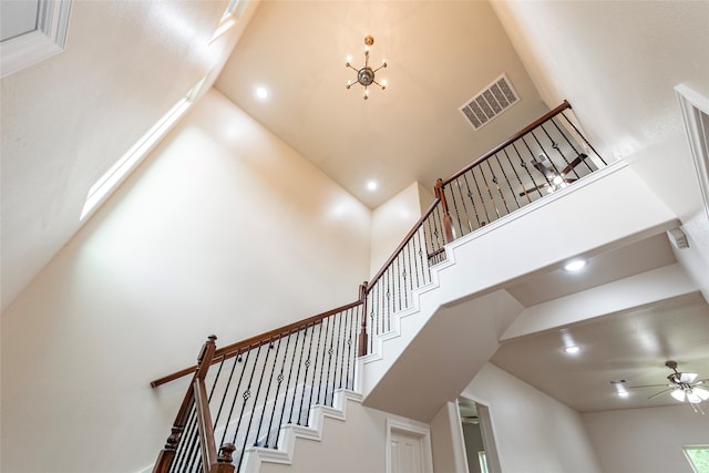 staircase with a high ceiling and ceiling fan