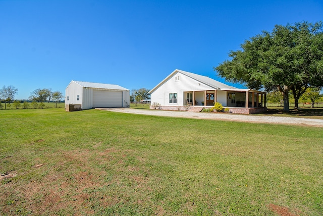 view of front facade featuring a front yard, an outdoor structure, a garage, and covered porch