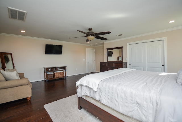 bedroom with crown molding, dark wood-type flooring, a closet, and ceiling fan