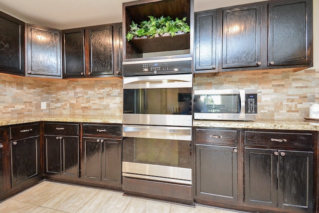 kitchen with appliances with stainless steel finishes, light stone countertops, tasteful backsplash, and dark brown cabinetry