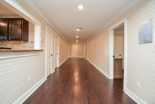 corridor with dark hardwood / wood-style floors and crown molding