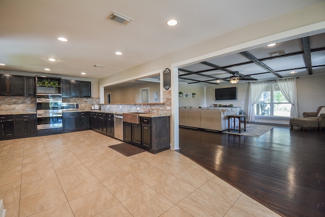 kitchen with light hardwood / wood-style floors, appliances with stainless steel finishes, tasteful backsplash, coffered ceiling, and ceiling fan