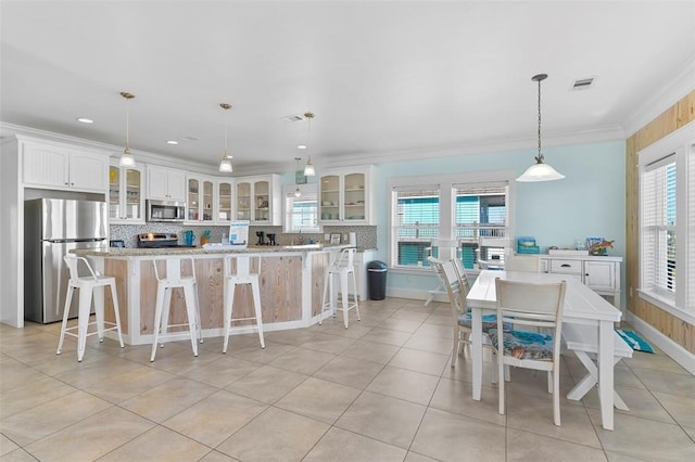 kitchen with stainless steel appliances, plenty of natural light, tasteful backsplash, and decorative light fixtures