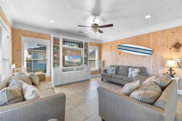 tiled living room featuring wood walls, ornamental molding, and ceiling fan