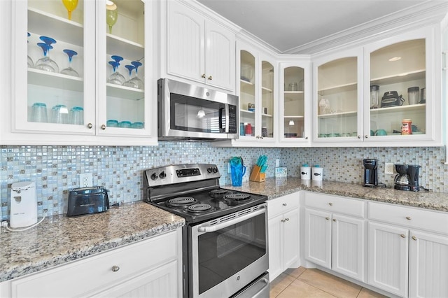 kitchen featuring white cabinets, tasteful backsplash, light tile floors, and stainless steel appliances