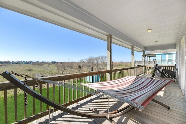 wooden deck featuring a rural view and a lawn