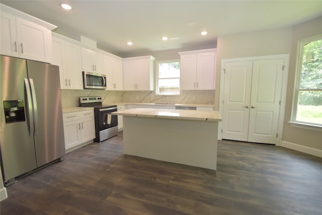 kitchen featuring a center island, stainless steel appliances, dark hardwood / wood-style flooring, and backsplash