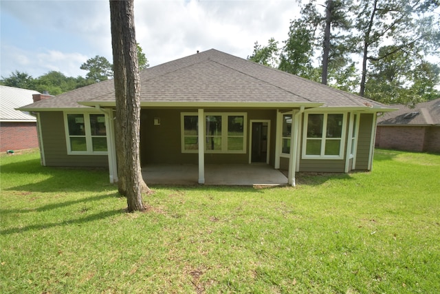 rear view of house with a patio and a lawn