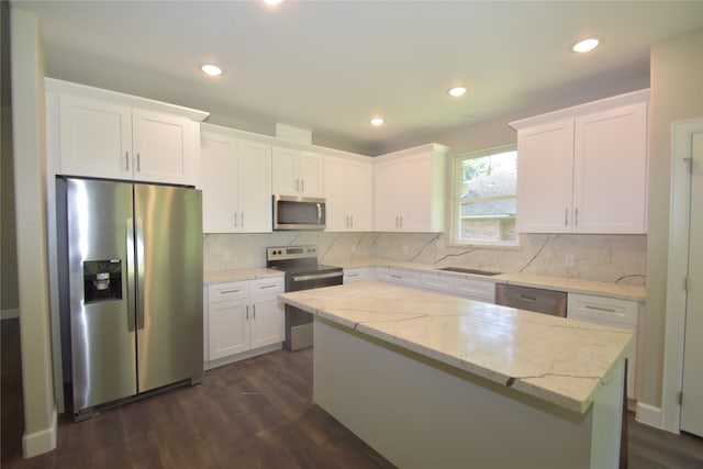 kitchen featuring dark hardwood / wood-style flooring, white cabinets, a kitchen island, and stainless steel appliances