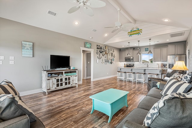 living room featuring ceiling fan, sink, hardwood / wood-style flooring, and beam ceiling