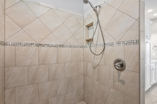 bathroom with a tile shower and vanity