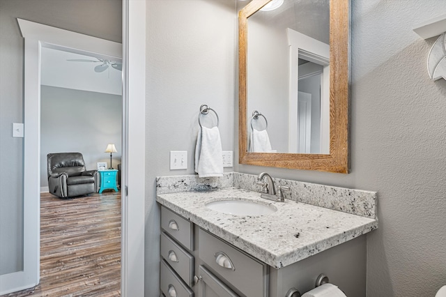 bathroom with ceiling fan, oversized vanity, and hardwood / wood-style floors