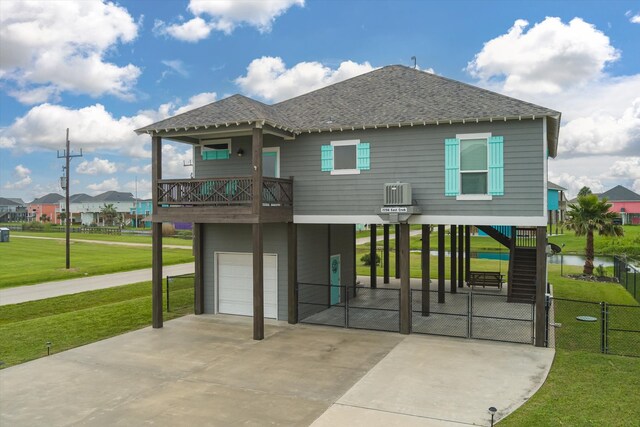 view of front facade featuring a garage, a front yard, and a balcony