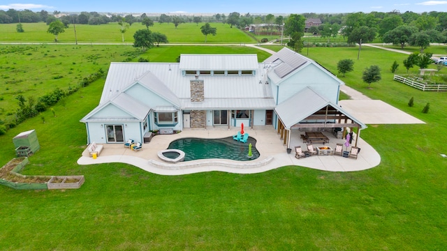 back of property featuring outdoor lounge area, a patio, and a rural view