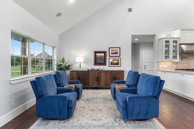 sitting room with dark hardwood / wood-style flooring and high vaulted ceiling