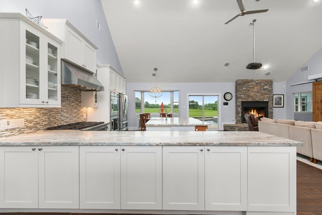 kitchen featuring a stone fireplace and white cabinets