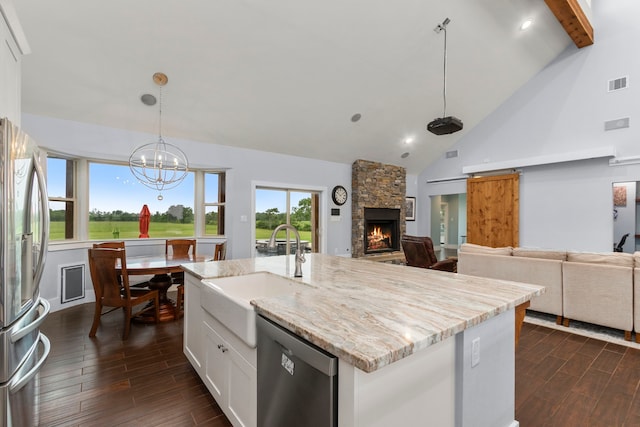 kitchen with white cabinetry, sink, dark wood-type flooring, hanging light fixtures, and stainless steel appliances