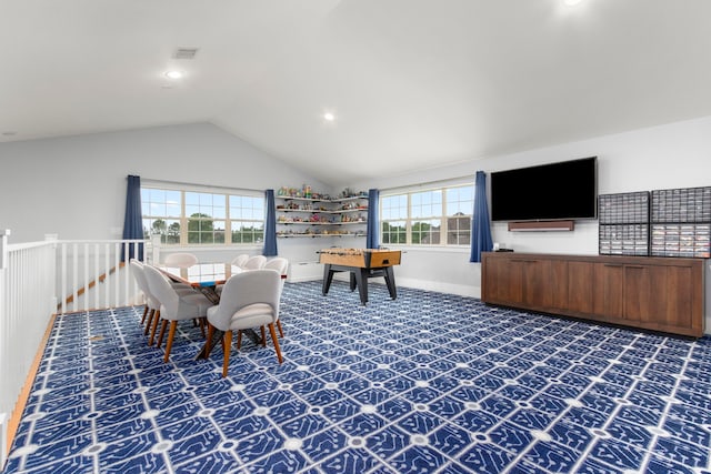 carpeted dining space featuring plenty of natural light and lofted ceiling