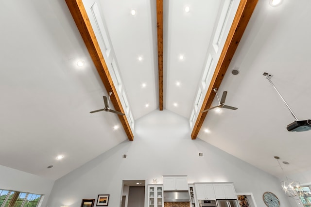 room details featuring stainless steel oven, ceiling fan with notable chandelier, hanging light fixtures, beam ceiling, and white cabinetry