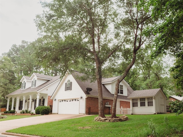 cape cod home featuring a garage and a front lawn