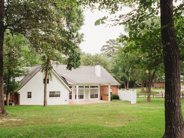 rear view of property with central air condition unit and a lawn