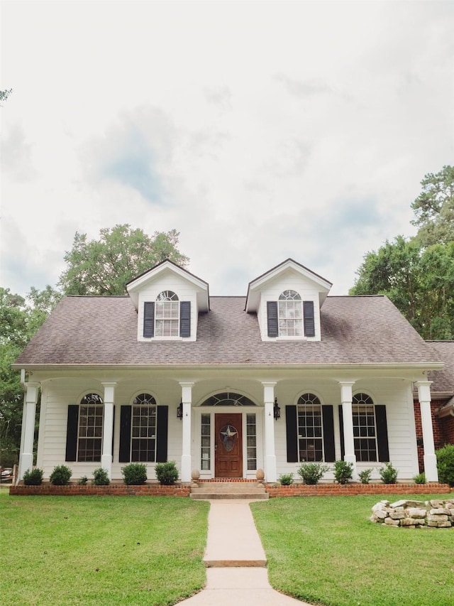 cape cod-style house with a front lawn and a porch