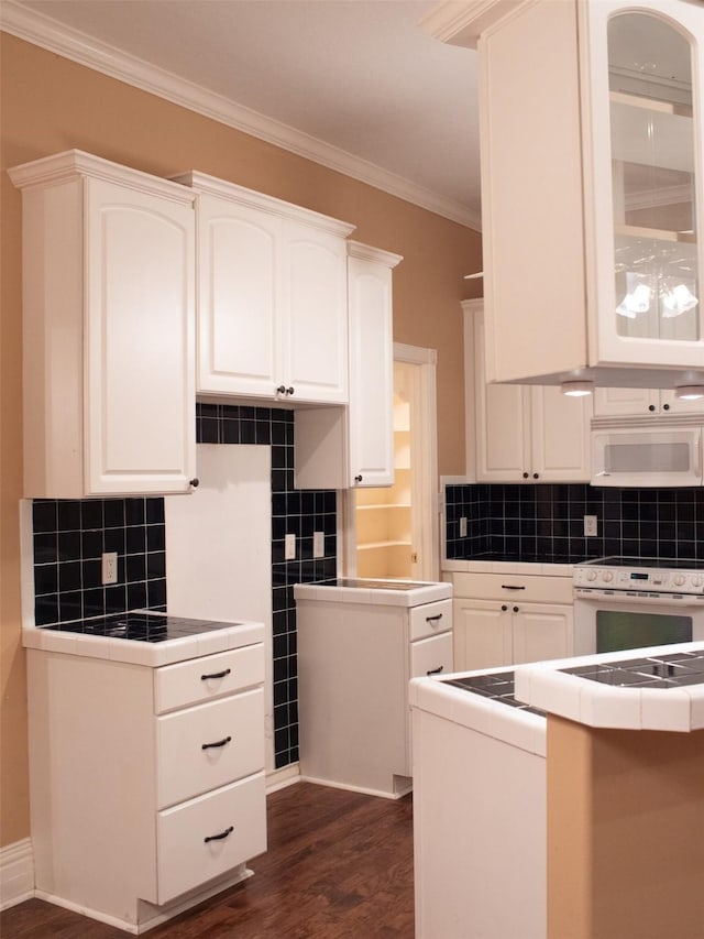 kitchen featuring decorative backsplash, white cabinetry, dark hardwood / wood-style flooring, and white appliances