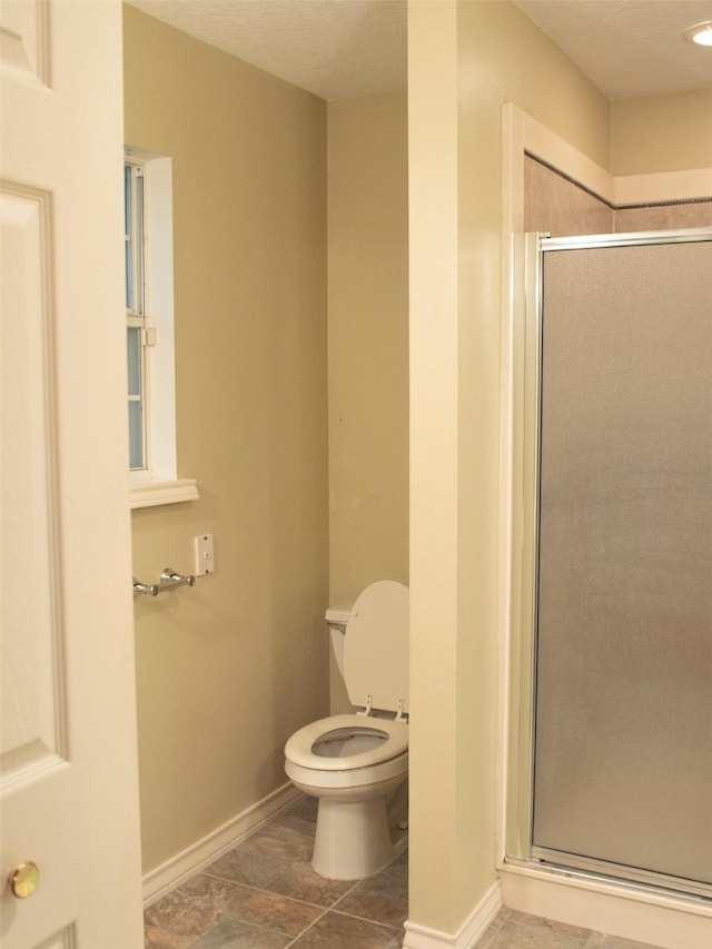 bathroom with tile patterned flooring, a textured ceiling, toilet, and an enclosed shower