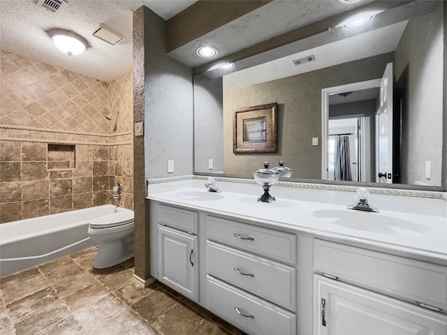 full bathroom featuring double vanity, toilet, tile floors, shower / bath combo, and a textured ceiling