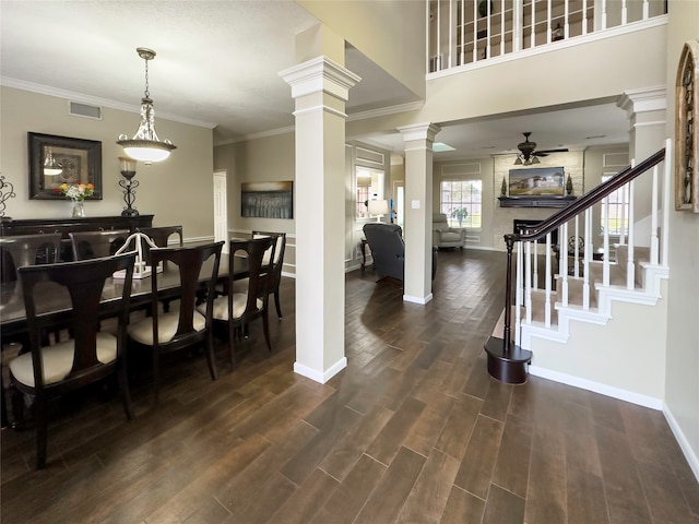 foyer with ceiling fan, dark hardwood / wood-style flooring, ornamental molding, and decorative columns