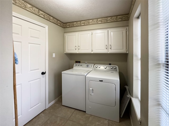 washroom featuring cabinets, tile flooring, a textured ceiling, and washing machine and dryer