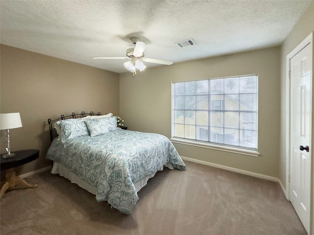 bedroom featuring a textured ceiling, carpet flooring, and ceiling fan