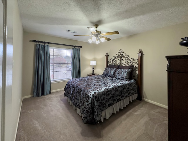 carpeted bedroom with ceiling fan and a textured ceiling