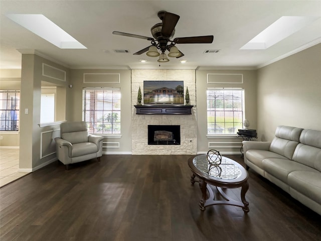 living room with ceiling fan, a skylight, and hardwood / wood-style floors