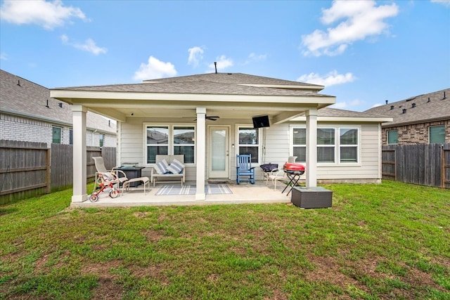 rear view of house with ceiling fan, a yard, and a patio area