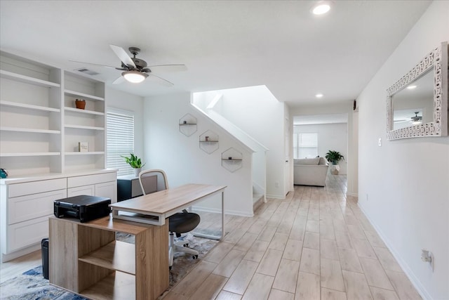 home office with light wood-type flooring and ceiling fan