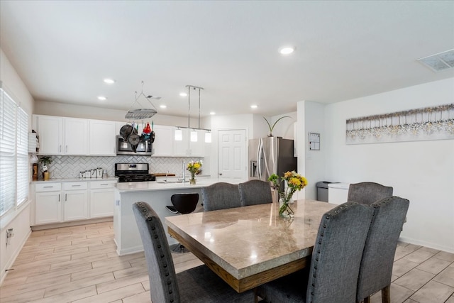 dining space featuring sink and light hardwood / wood-style flooring