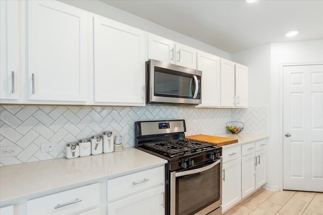 kitchen with white cabinets, decorative backsplash, and stainless steel appliances