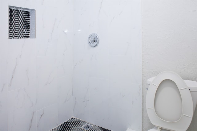 bathroom with tiled shower and toilet