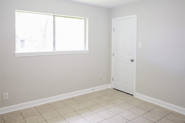 empty room with plenty of natural light and light tile floors