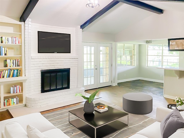 living room with french doors, a fireplace, wood-type flooring, lofted ceiling with beams, and brick wall