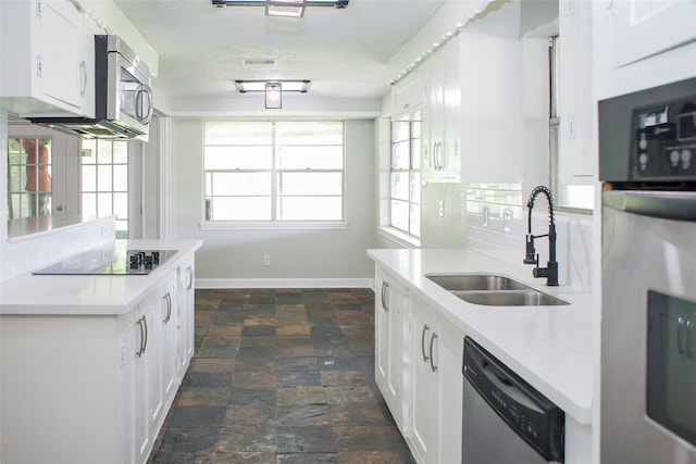 kitchen with backsplash, white cabinets, plenty of natural light, and dark tile floors