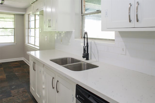 kitchen with backsplash, sink, white cabinetry, and dark tile floors